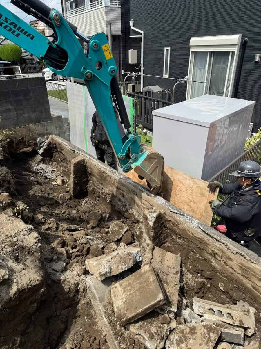 重機とともに既設のブロック塀を解体する奏陽建設のスタッフ
