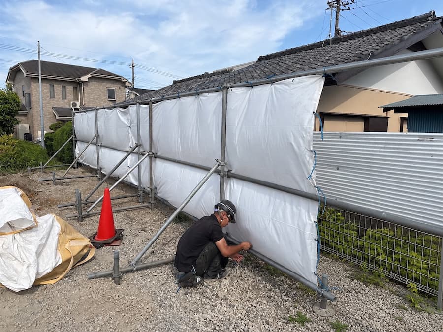 現場で足場を組み、養生シートを張る奏陽建設のスタッフ
